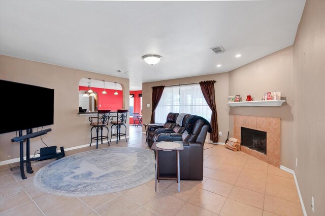 living room featuring light tile patterned floors and a tiled fireplace