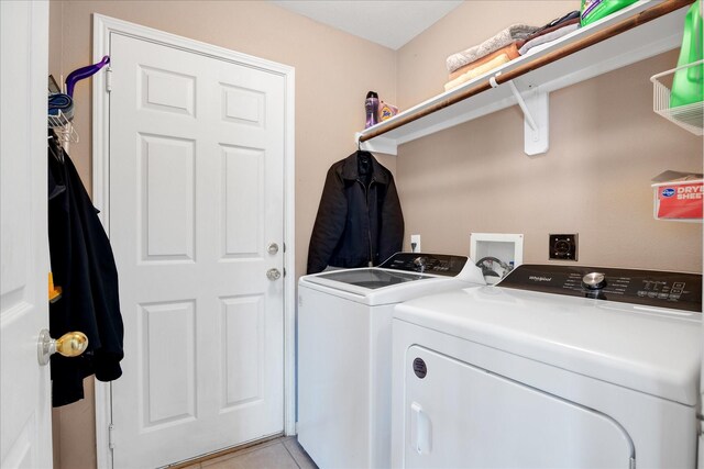 washroom featuring washer and clothes dryer and light tile patterned floors