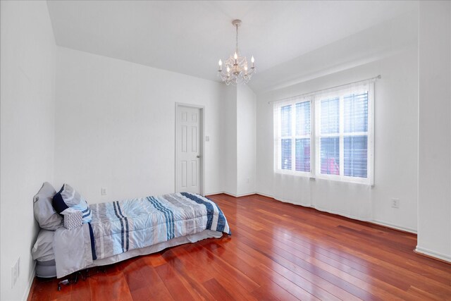 bedroom featuring hardwood / wood-style flooring and a chandelier