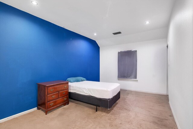 carpeted bedroom with vaulted ceiling