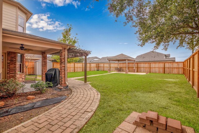 view of yard with ceiling fan, a storage shed, and a patio