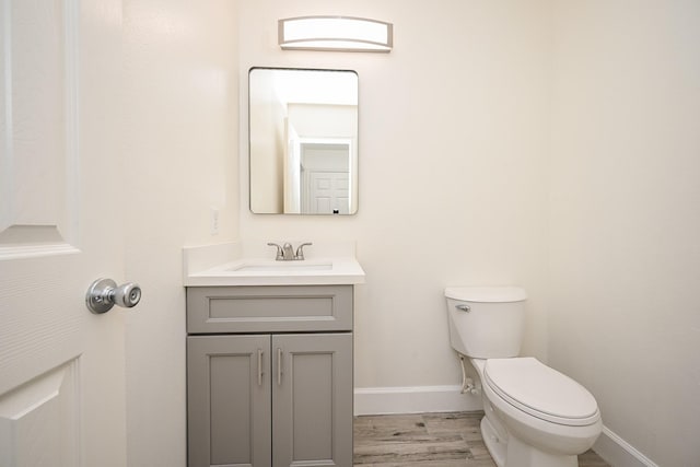 bathroom with vanity, wood-type flooring, and toilet