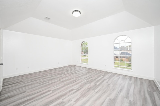 unfurnished room with a tray ceiling and light hardwood / wood-style floors