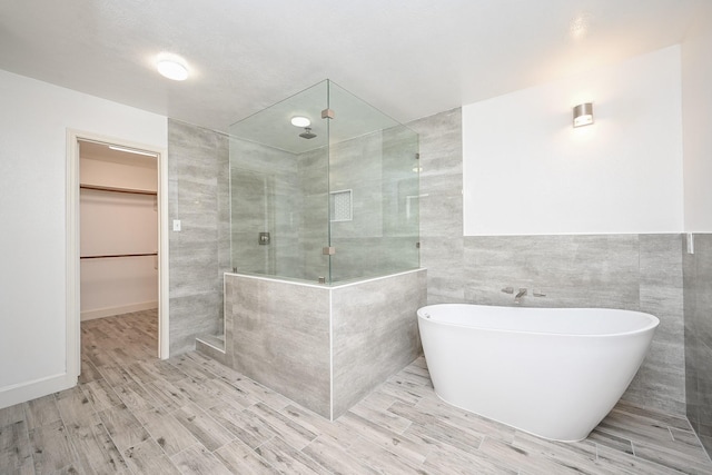 bathroom with separate shower and tub and tile walls