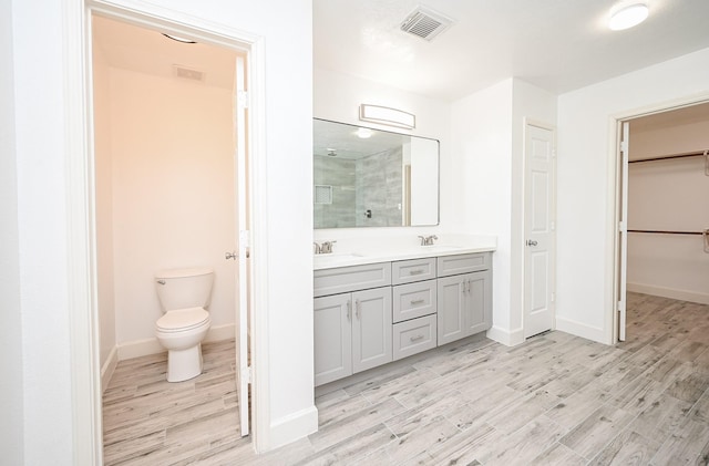 bathroom featuring hardwood / wood-style floors, vanity, toilet, and an enclosed shower