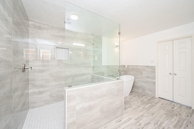 bathroom featuring separate shower and tub and tile walls