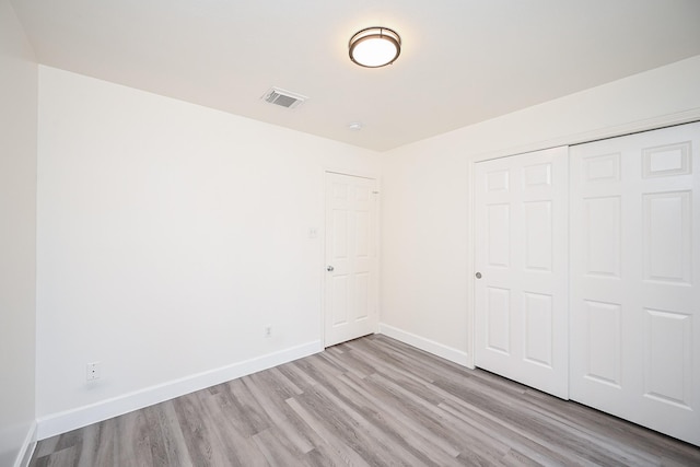 unfurnished bedroom featuring a closet and light hardwood / wood-style floors