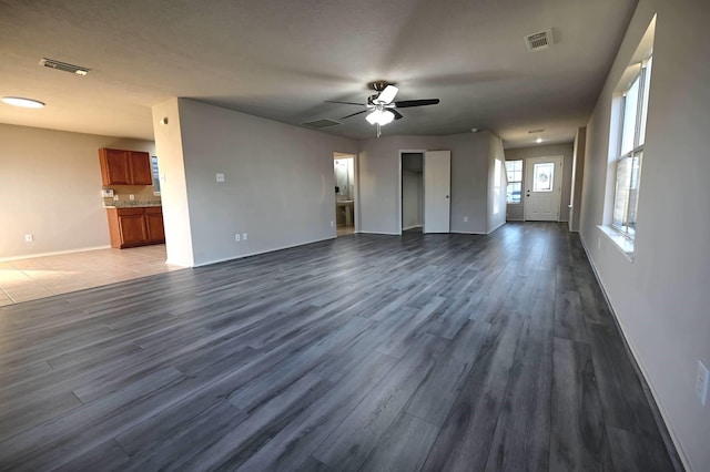 unfurnished living room featuring ceiling fan and hardwood / wood-style flooring