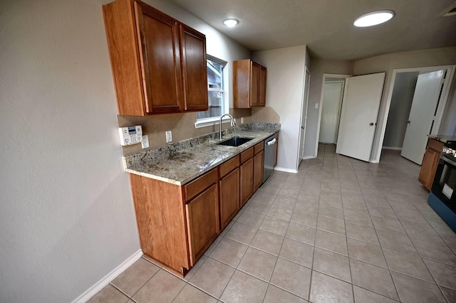 kitchen featuring light stone countertops, sink, stainless steel dishwasher, and light tile patterned floors