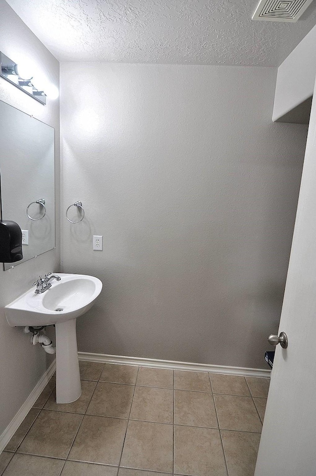 bathroom featuring tile patterned flooring and a textured ceiling