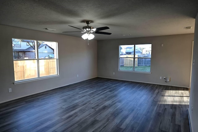 empty room with ceiling fan, dark hardwood / wood-style flooring, and a textured ceiling