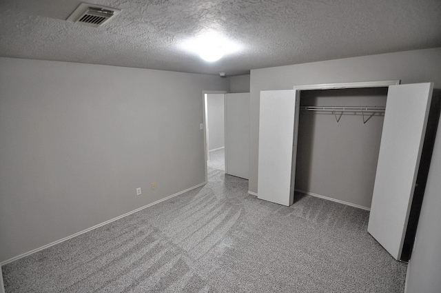 unfurnished bedroom featuring a closet, a textured ceiling, and carpet flooring