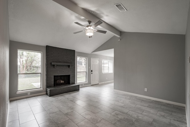 unfurnished living room with ceiling fan, plenty of natural light, lofted ceiling with beams, and a brick fireplace