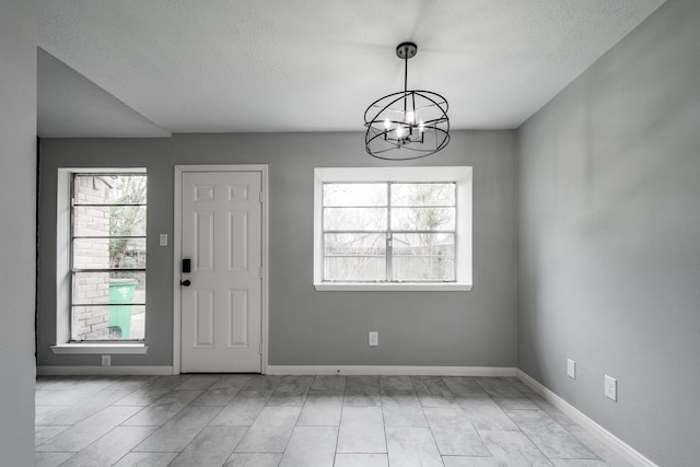 foyer entrance featuring a textured ceiling and an inviting chandelier