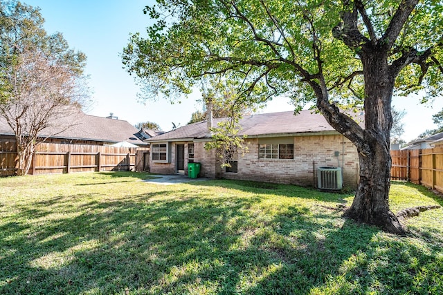 back of property featuring a lawn and central air condition unit