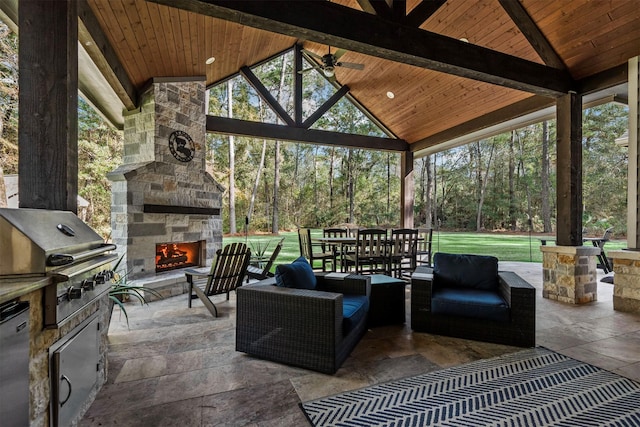 view of patio / terrace featuring an outdoor living space with a fireplace, a gazebo, a grill, outdoor dining area, and an outdoor kitchen