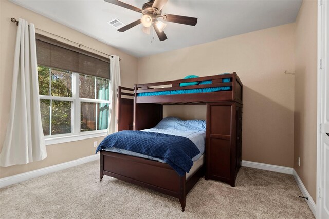 bedroom with baseboards, light carpet, visible vents, and ceiling fan