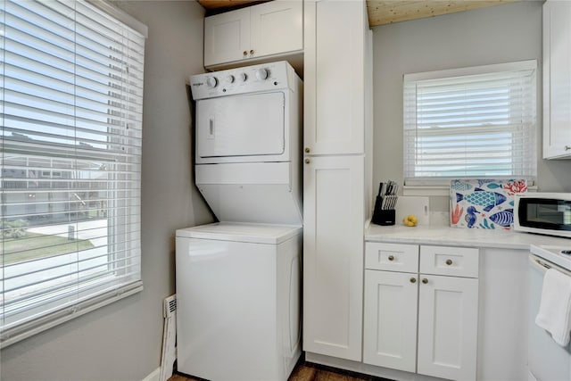 laundry area with dark hardwood / wood-style flooring and stacked washer and clothes dryer