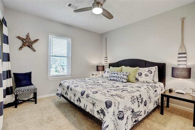 carpeted bedroom with ceiling fan and a textured ceiling