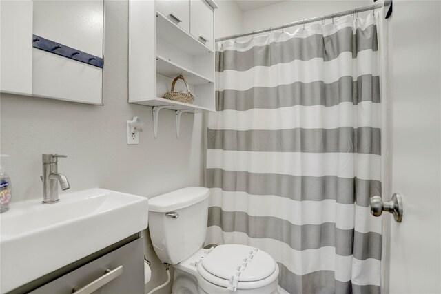 bathroom with vanity, toilet, and walk in shower