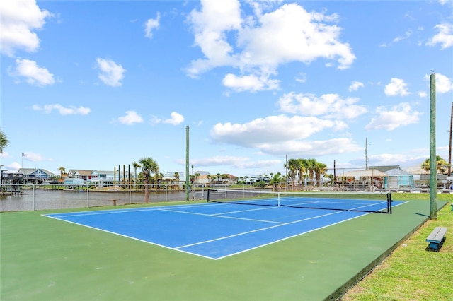 view of sport court featuring basketball hoop and a water view