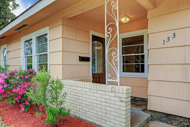 view of exterior entry featuring covered porch