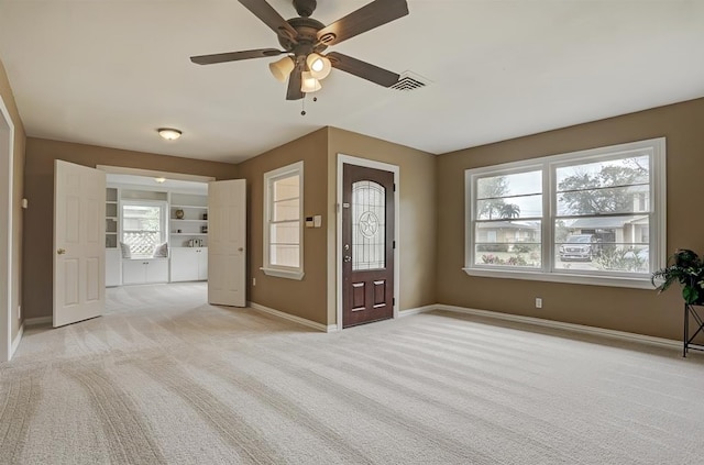 foyer with ceiling fan, washing machine and dryer, and light carpet