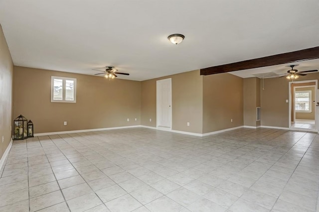 tiled spare room with beam ceiling, a wealth of natural light, and ceiling fan