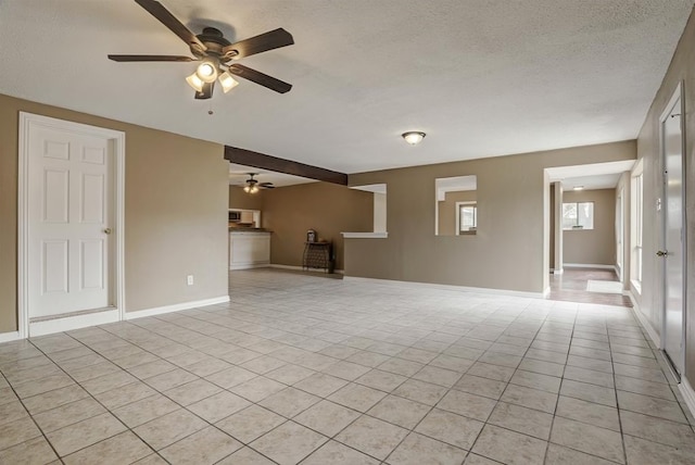 unfurnished living room with ceiling fan, light tile patterned floors, and a textured ceiling