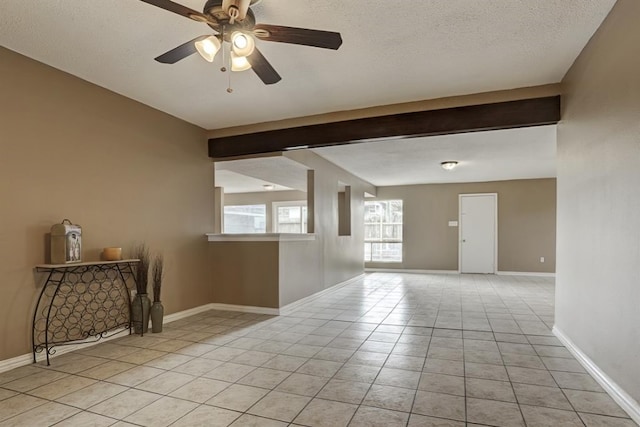 unfurnished room with a textured ceiling, ceiling fan, and light tile patterned flooring