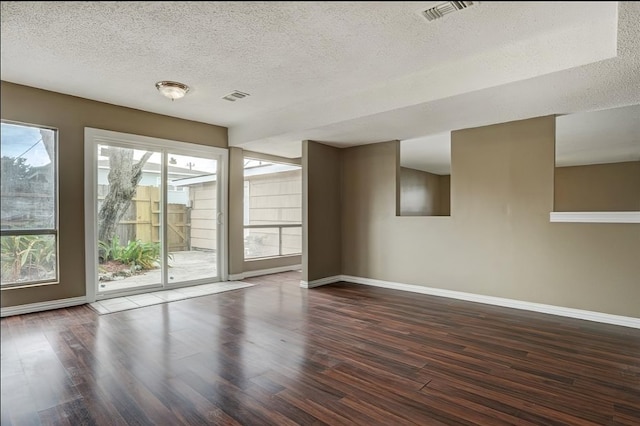 spare room with dark hardwood / wood-style flooring and a textured ceiling