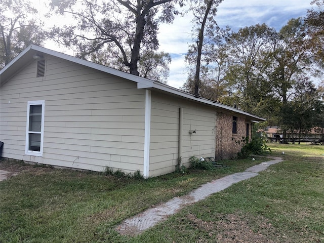 view of side of home with a yard