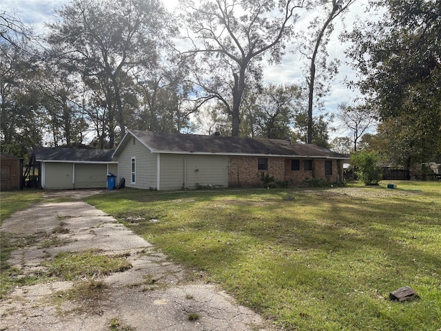 back of house featuring a yard and a garage