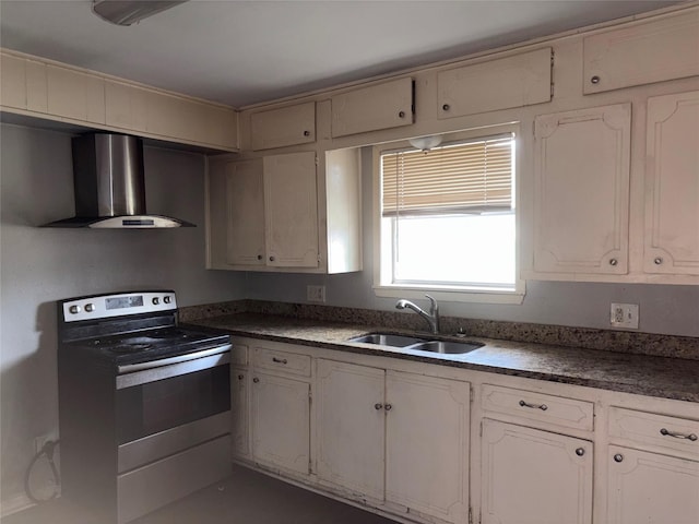 kitchen with stainless steel electric stove, white cabinetry, wall chimney range hood, and sink