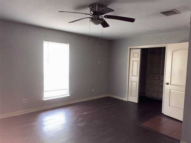 unfurnished bedroom featuring a closet, ceiling fan, dark hardwood / wood-style flooring, and a textured ceiling