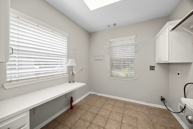 laundry room with electric dryer hookup, hookup for a washing machine, light tile patterned flooring, and cabinets