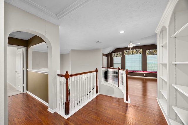 hall featuring a textured ceiling, dark hardwood / wood-style floors, and ornamental molding