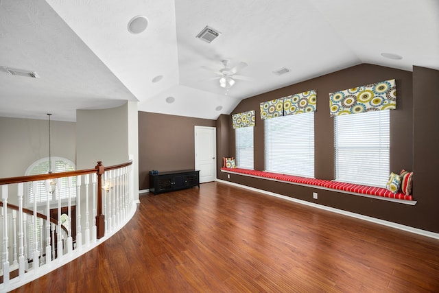 unfurnished room with ceiling fan with notable chandelier, dark hardwood / wood-style flooring, plenty of natural light, and lofted ceiling