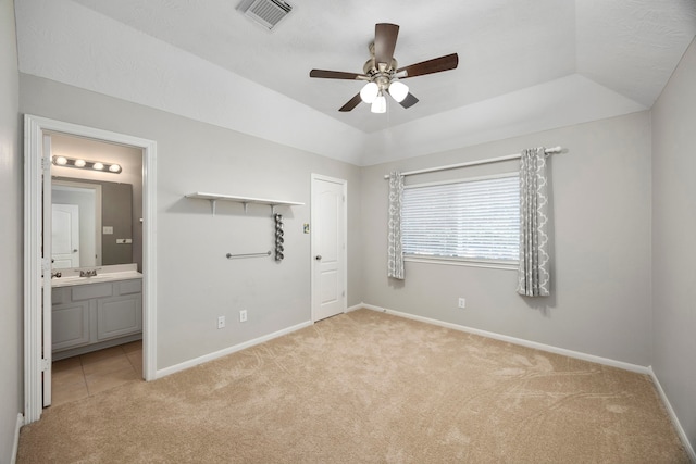 unfurnished bedroom featuring light carpet, ceiling fan, connected bathroom, a closet, and lofted ceiling