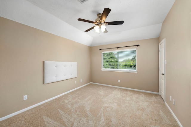 carpeted empty room with vaulted ceiling and ceiling fan