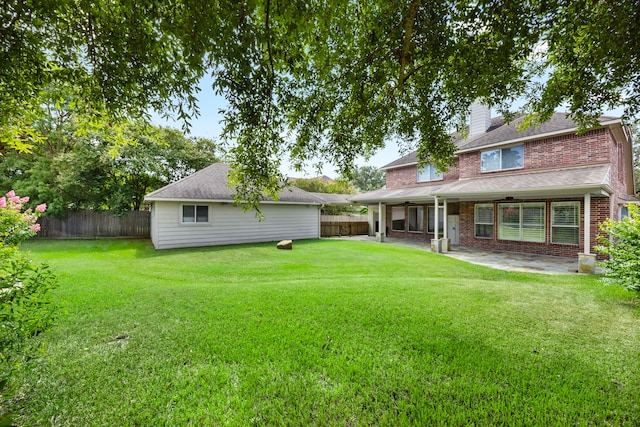 rear view of property featuring a yard and a patio area