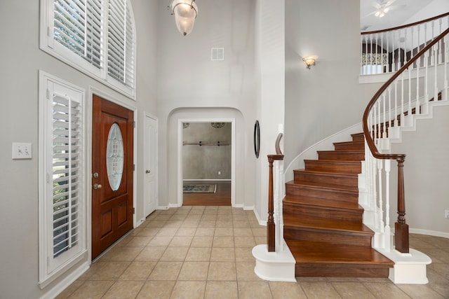 entryway featuring light tile patterned flooring and a high ceiling