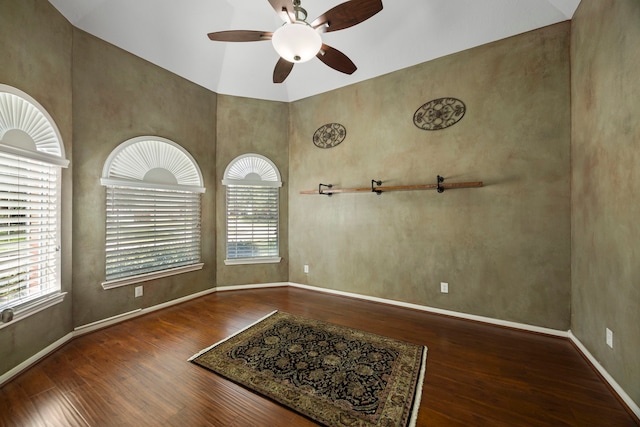 empty room featuring dark hardwood / wood-style flooring, high vaulted ceiling, and ceiling fan