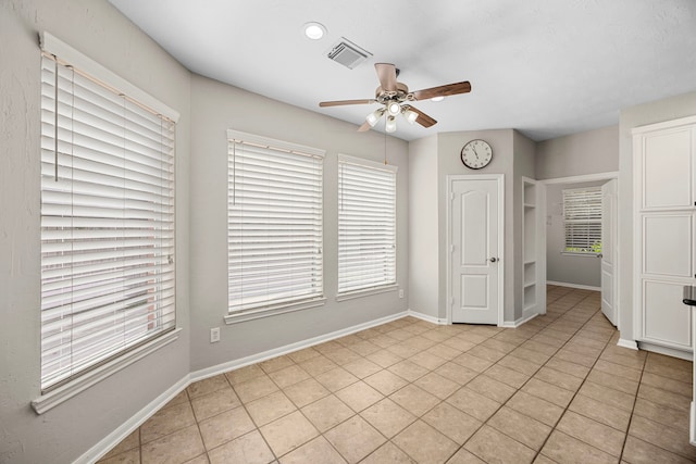 tiled empty room with ceiling fan