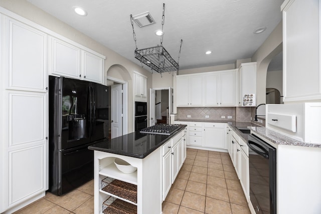 kitchen with black appliances, sink, tasteful backsplash, a kitchen island, and white cabinetry