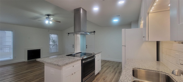 kitchen featuring ceiling fan, island exhaust hood, stainless steel electric range oven, light stone countertops, and white cabinets