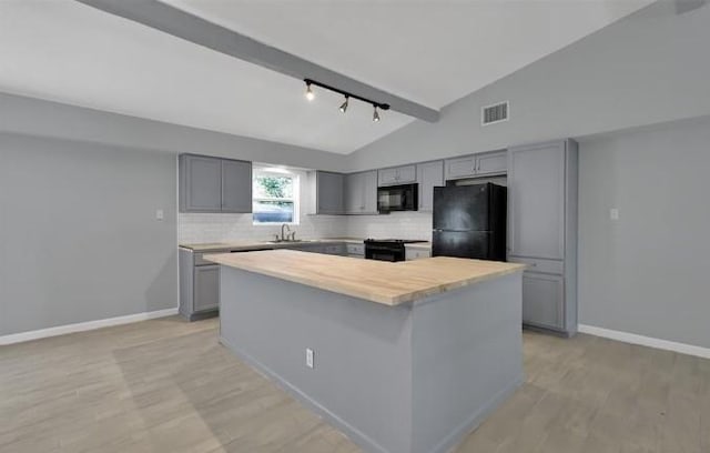 kitchen featuring rail lighting, wooden counters, gray cabinets, a kitchen island, and black appliances