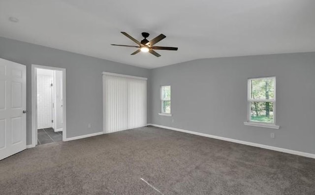 unfurnished bedroom with ceiling fan, vaulted ceiling, and dark colored carpet