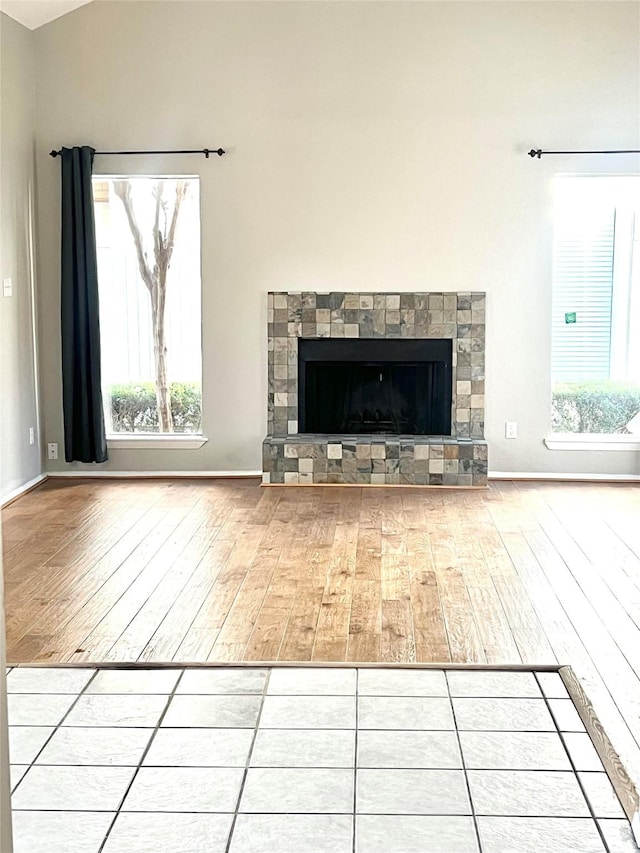 7854 Green Lawn Dr Unit 7854, Houston, TX 77088 - unfurnished living room with hardwood / wood-style floors, a fireplace with raised hearth, and vaulted ceiling