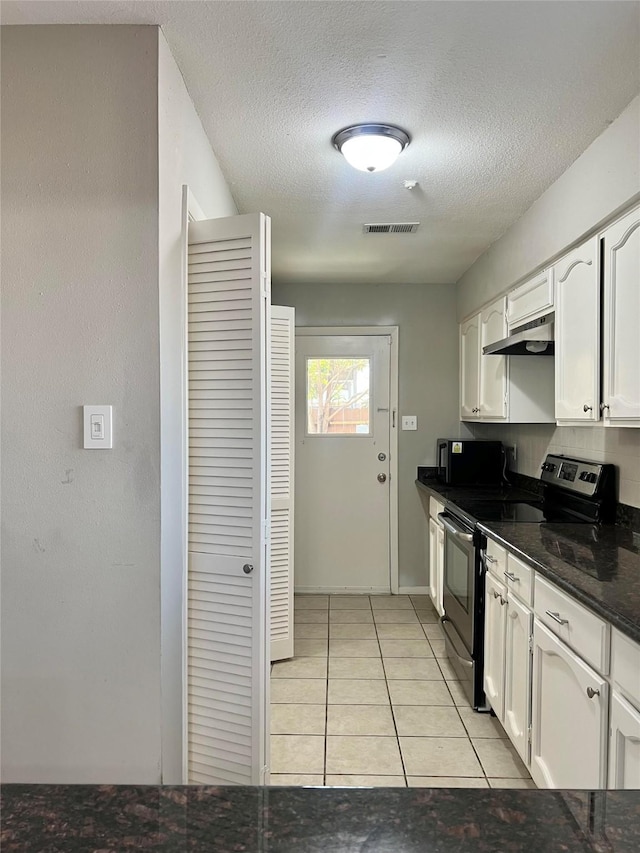 7854 Green Lawn Dr Unit 7854, Houston, TX 77088 - kitchen featuring electric range, under cabinet range hood, white cabinets, light tile patterned floors, and a textured ceiling